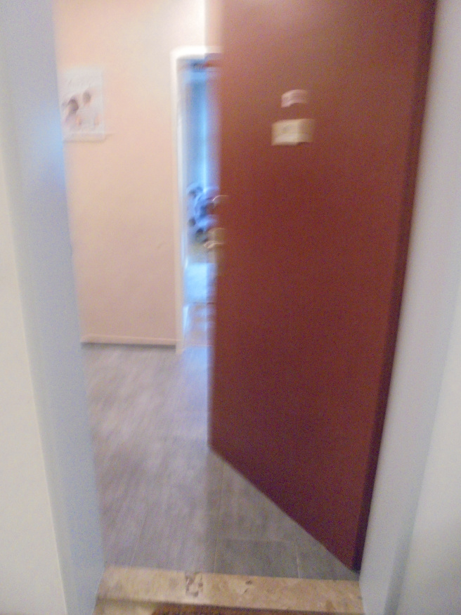 Tür im Flur mit Bild an der Wand und offener Tür in ein Zimmer