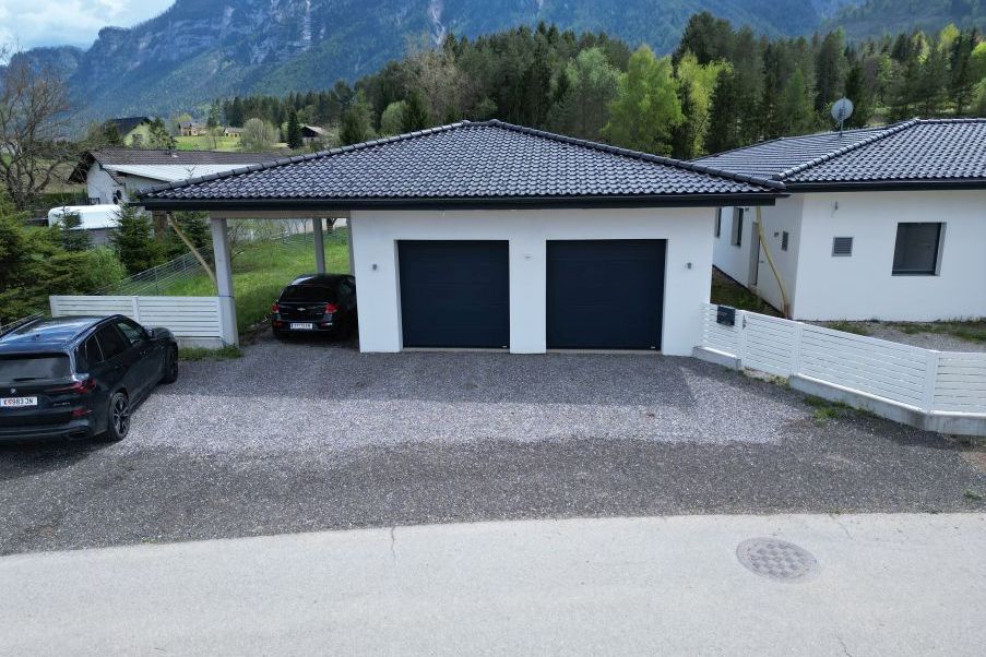 Doppelgarage mit Carport und Autos in Bergregion, Österreich