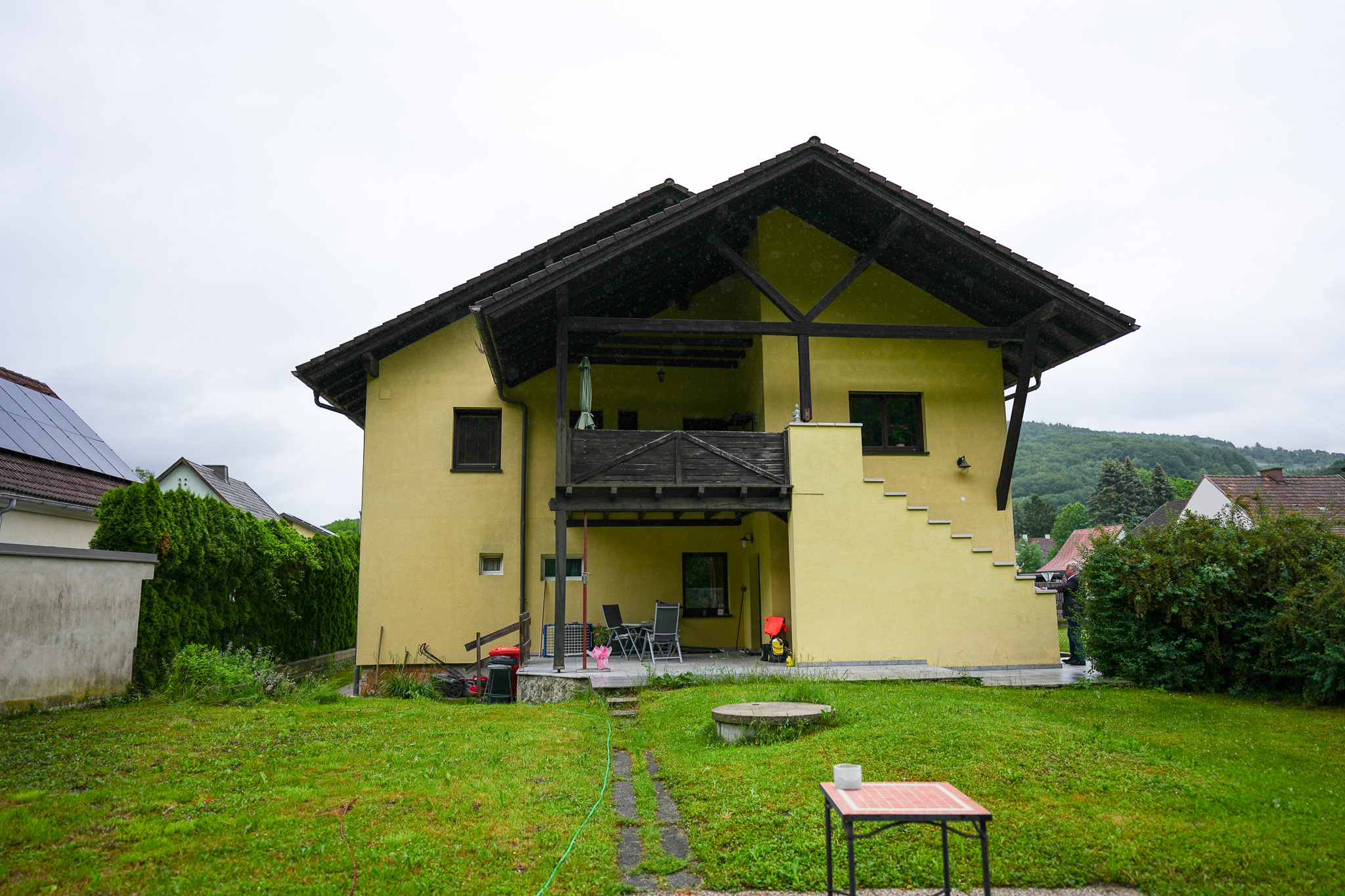 Gelbes Haus mit Holzveranda und Garten in Österreich