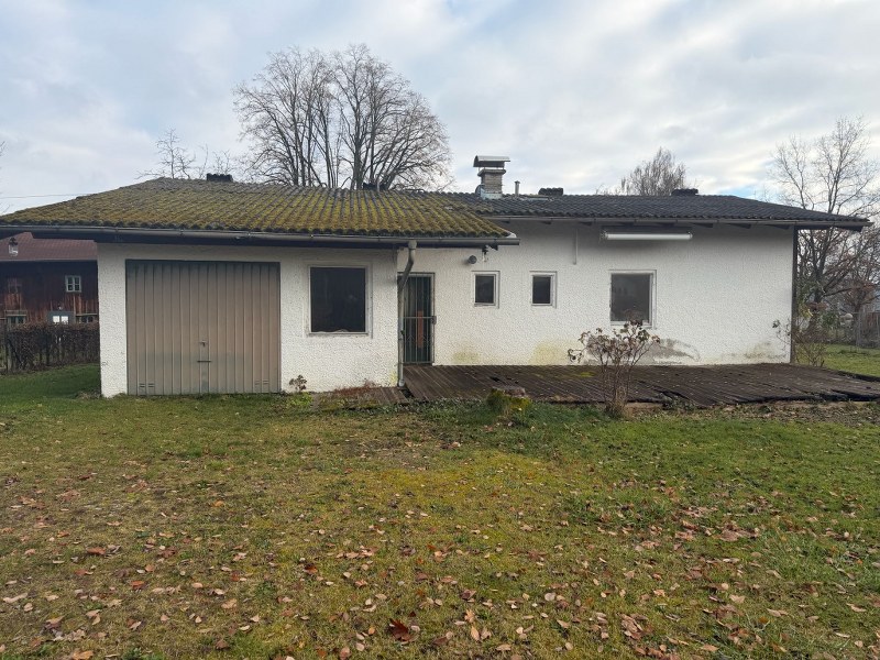 Garage und Haus mit Terrasse in ländlicher Umgebung.
