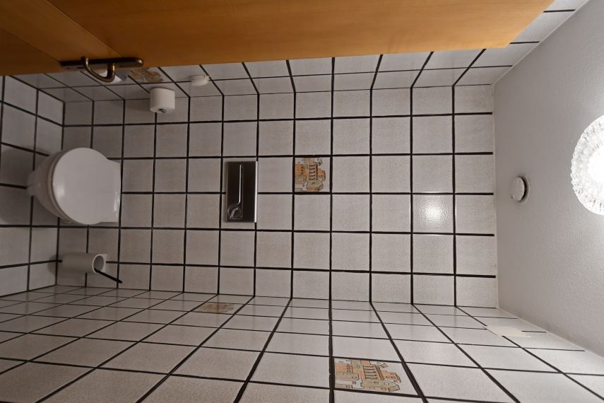 WC und Waschbecken mit Kacheln und Bildern von Häusern im Badezimmer