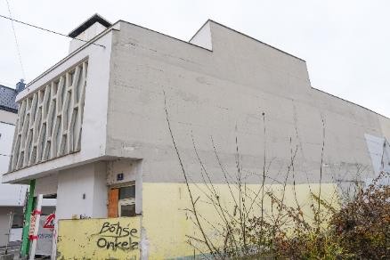 Gebäude mit auffälliger Fensterfront und Graffiti in Wien
