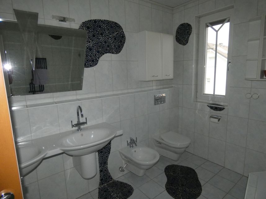 Badezimmer mit Waschbecken, Bidet und WC, Fenster und Spiegel, Fliesen mit Muster
