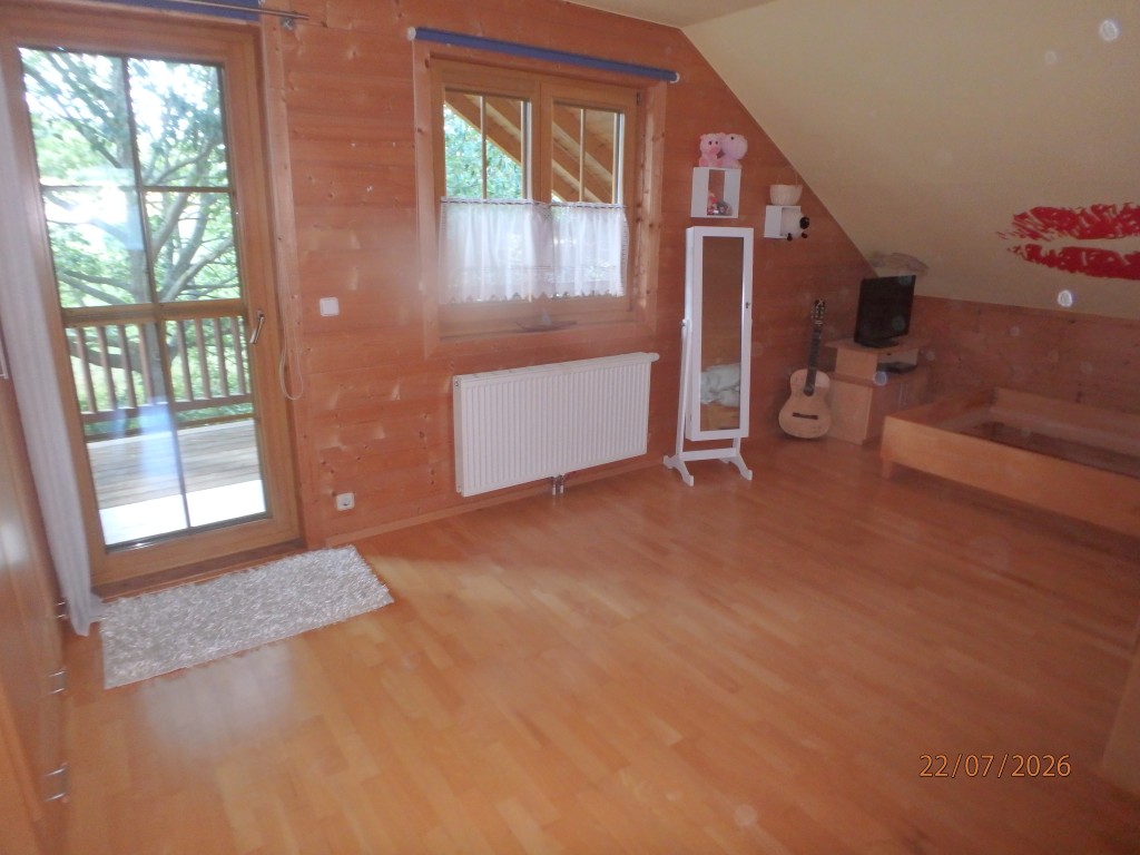 Holzzimmer mit Bett, Gitarre und Spiegel
