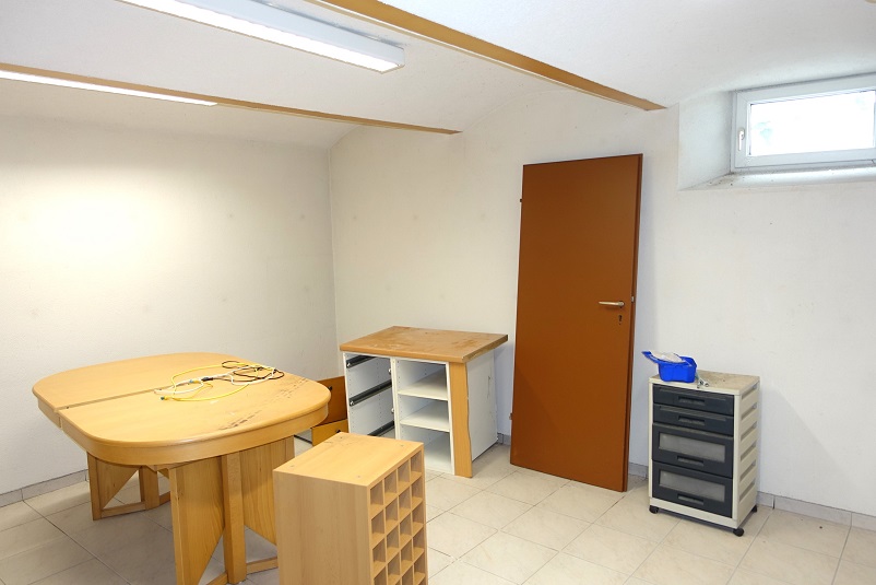 Holztisch mit Kabeln, Holzmöbel und Schubladenschrank in einem leeren Raum