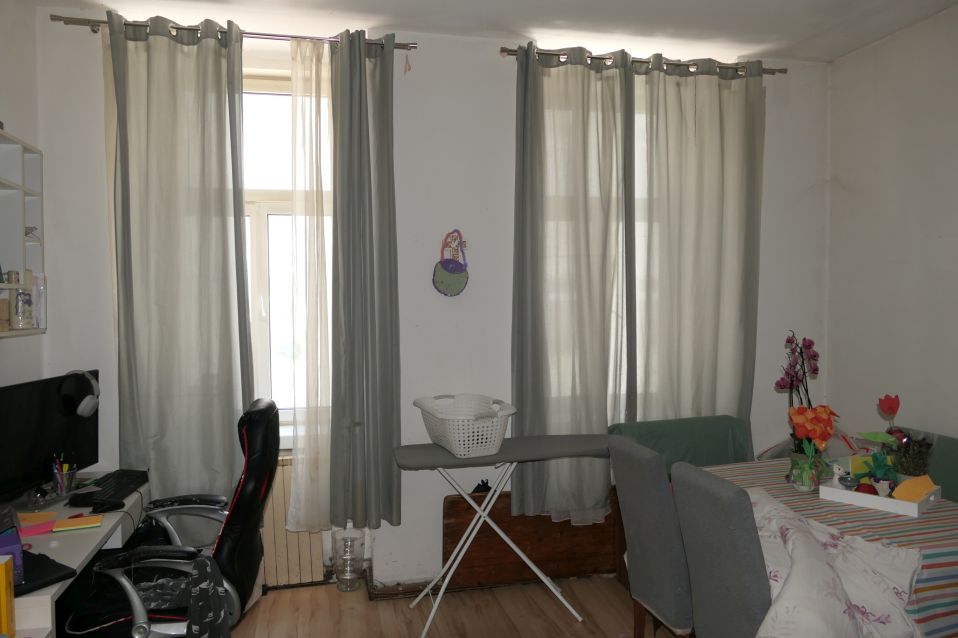 Büro und Essbereich mit Vorhängen, Bügelbrett und Blumen
