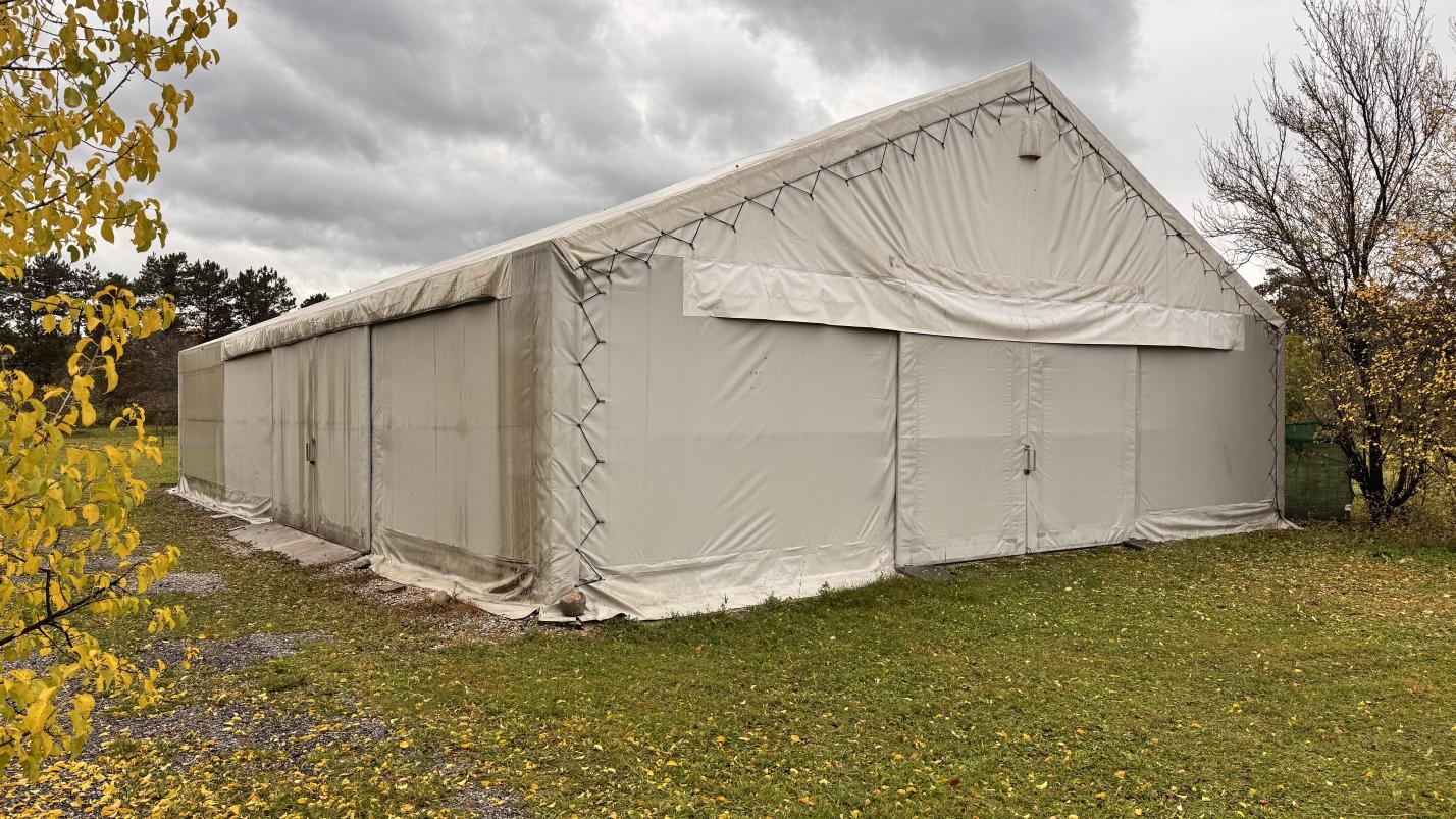 Großes Zelt mit Schiebetüren und Satteldach im Freien auf Grasboden