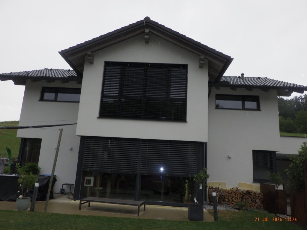 Modernes Einfamilienhaus mit großen Fenstern und Rollläden in Österreich