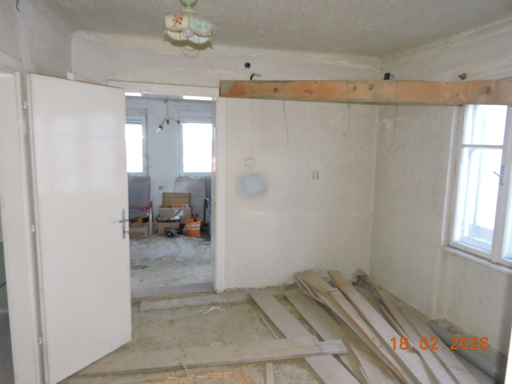 Umbau: Offene Tür und Holzbalken im Zimmer