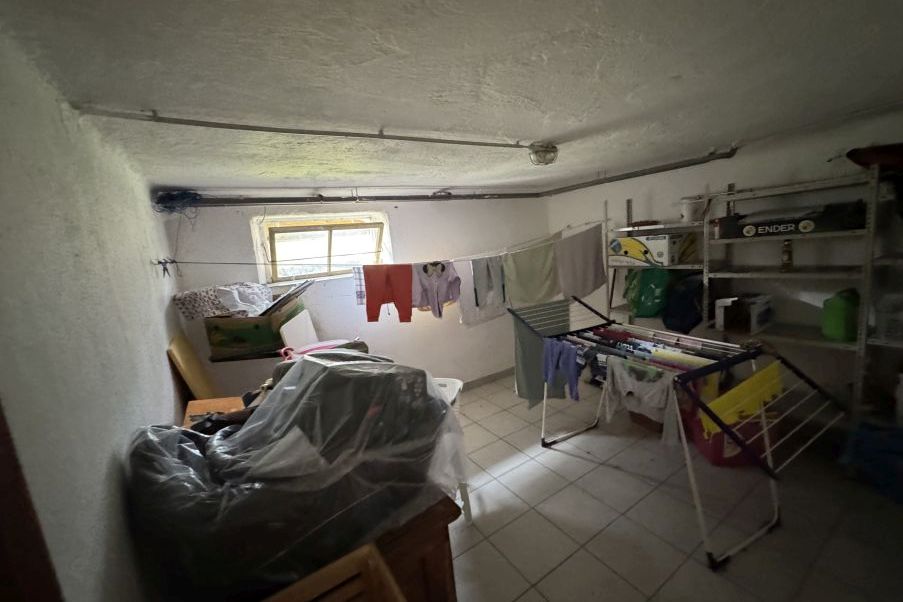 Wäscheleine mit Kleidung im Keller, Wäscheständer mit Kleidung, Lagerregal mit Gegenständen