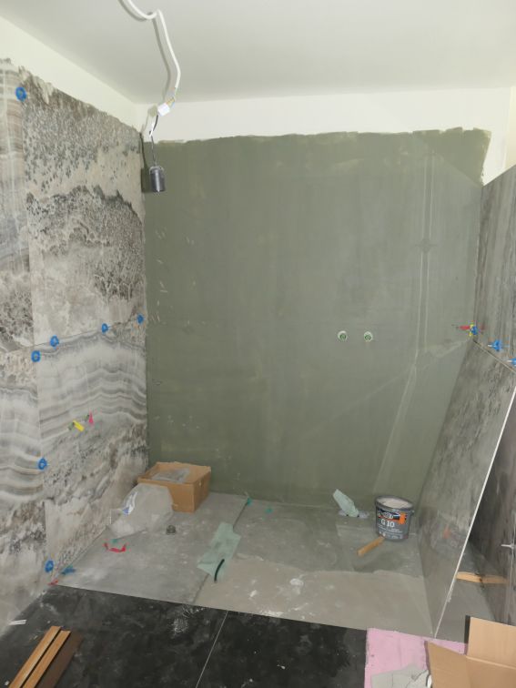Badezimmer im Umbau mit Marmorfliesen, Putz und Material in Wien