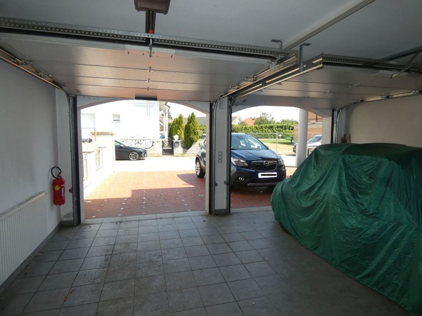Doppelgarage mit zwei Autos, eines abgedeckt, und Feuerlöscher