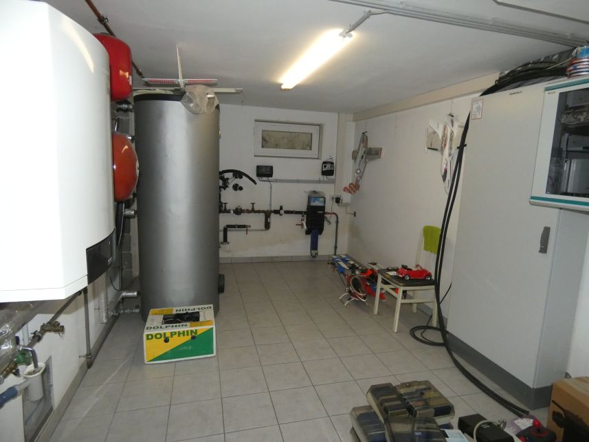 Heizungstechnik mit großem Warmwasserspeicher und Kessel in einem Raum