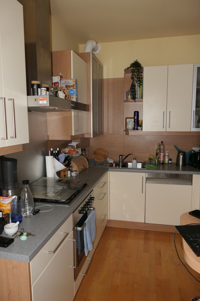 Küche mit Einbauküche, Herd und Spüle in Wien