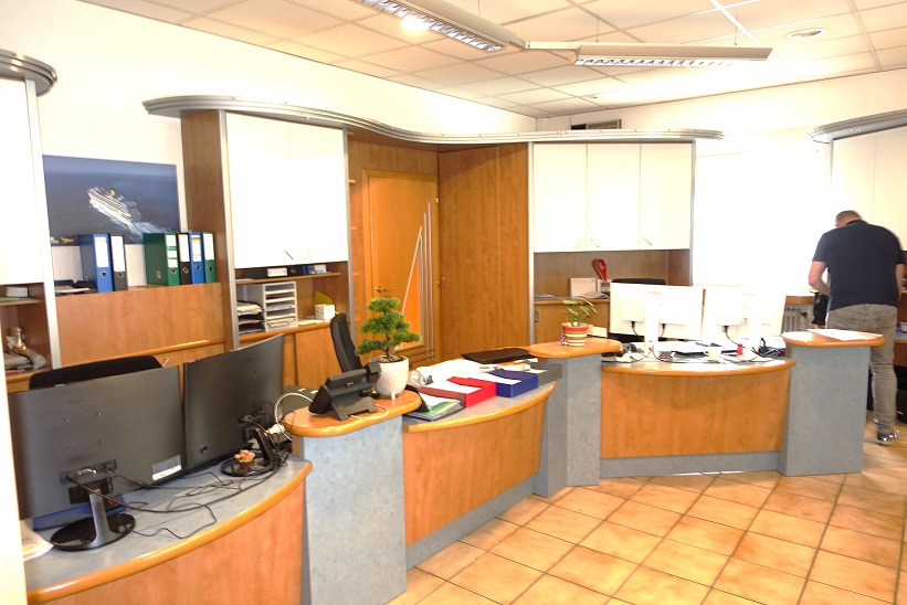 Büro mit Rezeption, Computern und Mann
