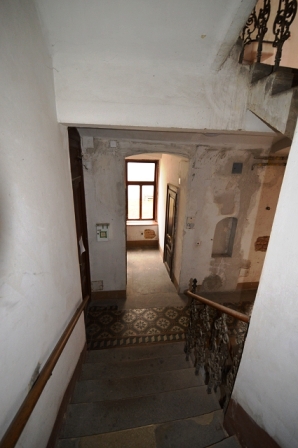 Treppenhaus mit ornamentierter Fliese und altem Geländer in Wien