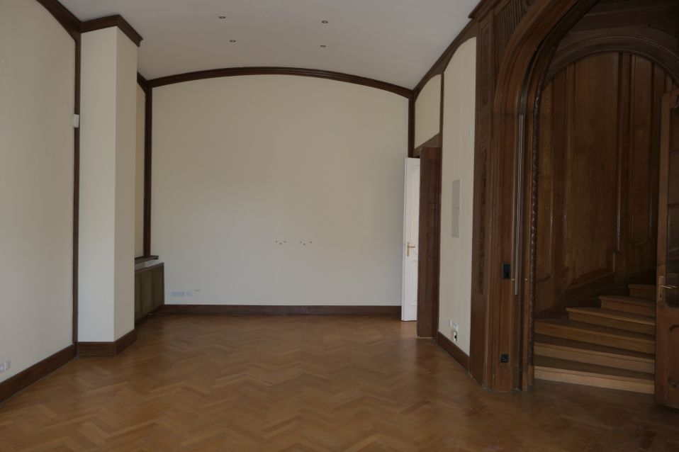 Parkettboden und Holzvertäfelung in einem leeren Raum mit Treppenaufgang
