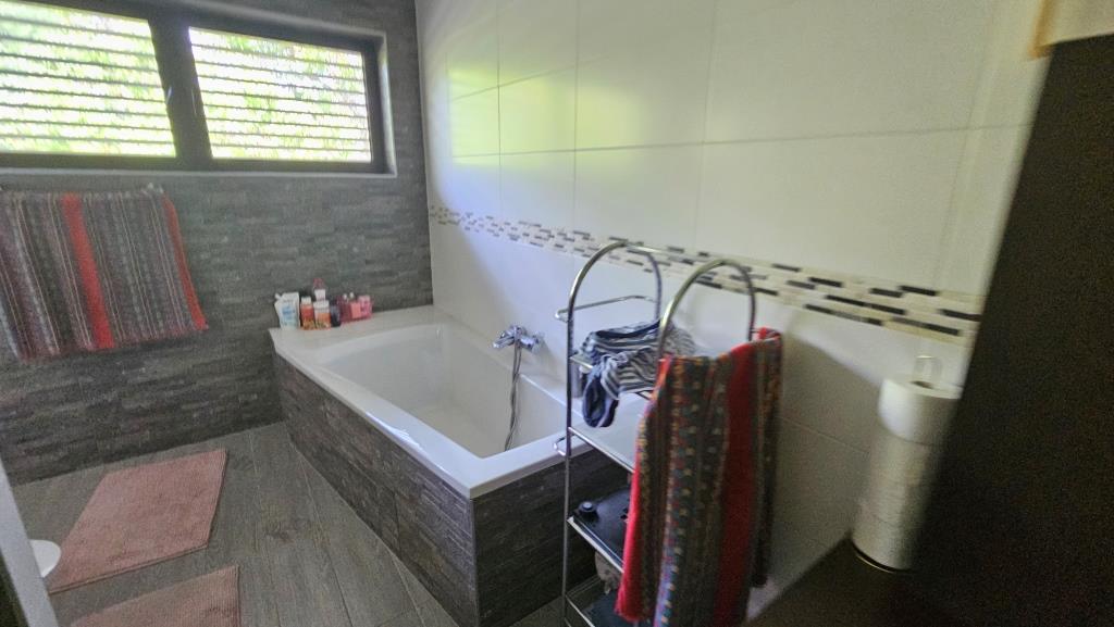 Badezimmer mit Badewanne, Handtüchern und Fenster
