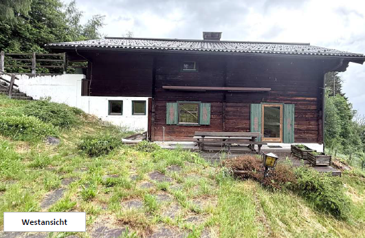 Holzhaus mit Sitzbank und Tisch, Westansicht, Österreich