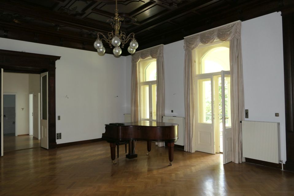 Flügel im prunkvollen Salon mit Holzboden und stuckierter Decke
