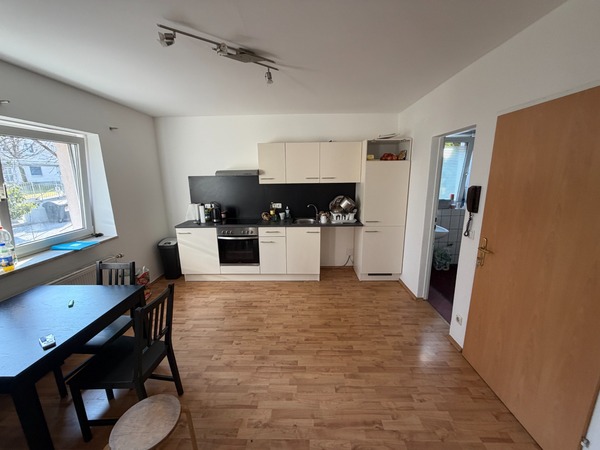 Kleine Küche mit Essbereich und Tür zu einem weiteren Raum in Wien