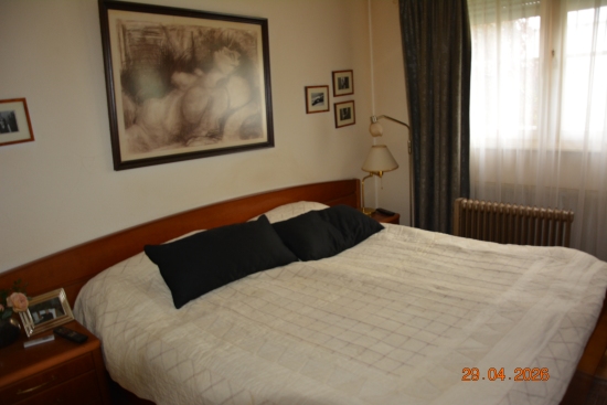 Schlafzimmer mit Doppelbett, Kunstwerk und Nachtkästchen
