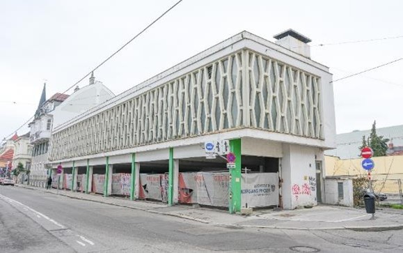Gebäude mit auffälliger Fassade und Parkplätzen, Wien