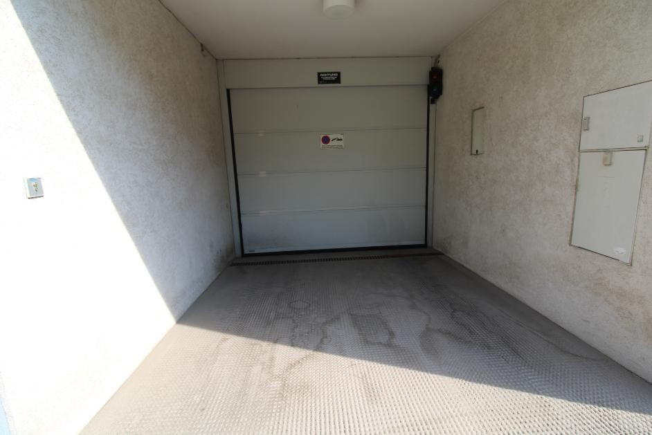 Garagentor mit Hinweisschild und Ampel im Eingangsbereich einer Tiefgarage