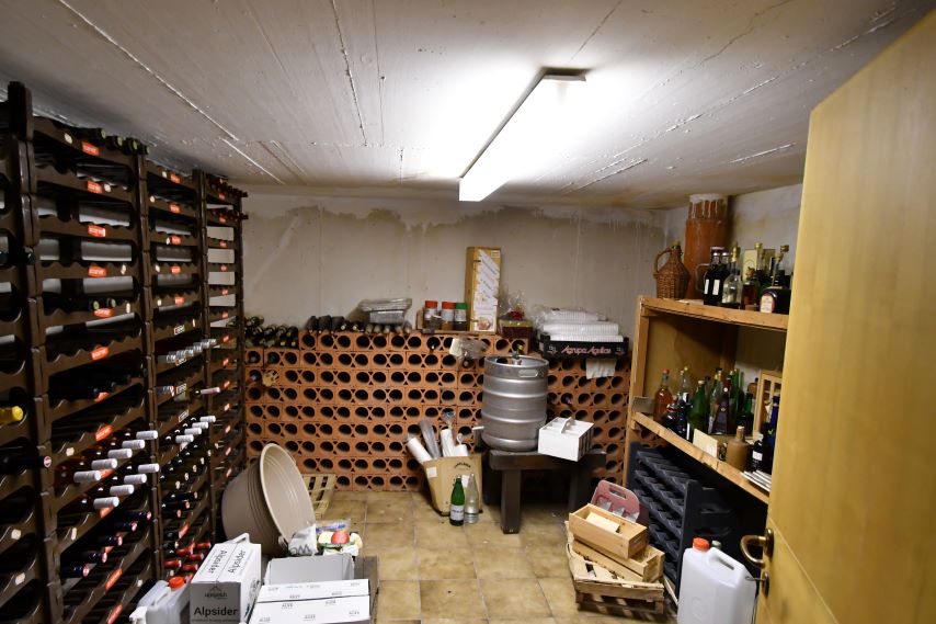 Keller mit Weinregalen, Bierfass, Flaschen und Tonröhrenlager