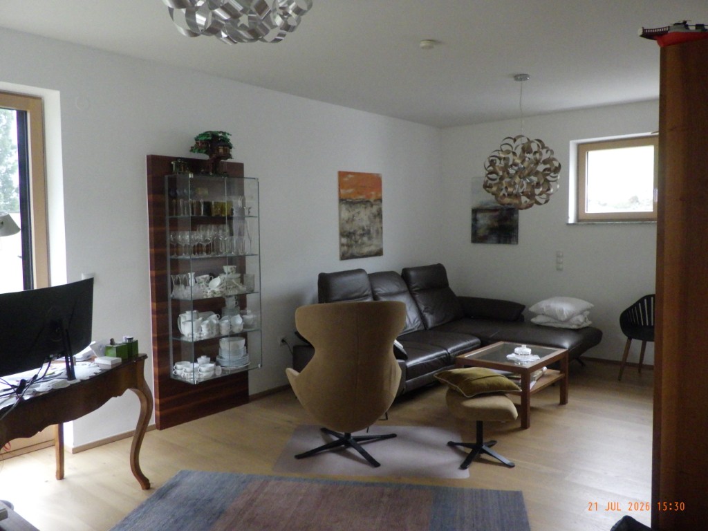 Wohnzimmer mit Ledercouch, Vitrine und Eames-Sessel