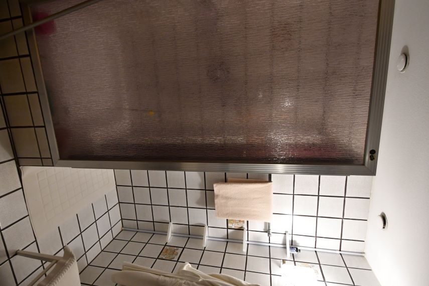 Duschkabine mit Milchglas und gefliesten Wänden in einem Badezimmer