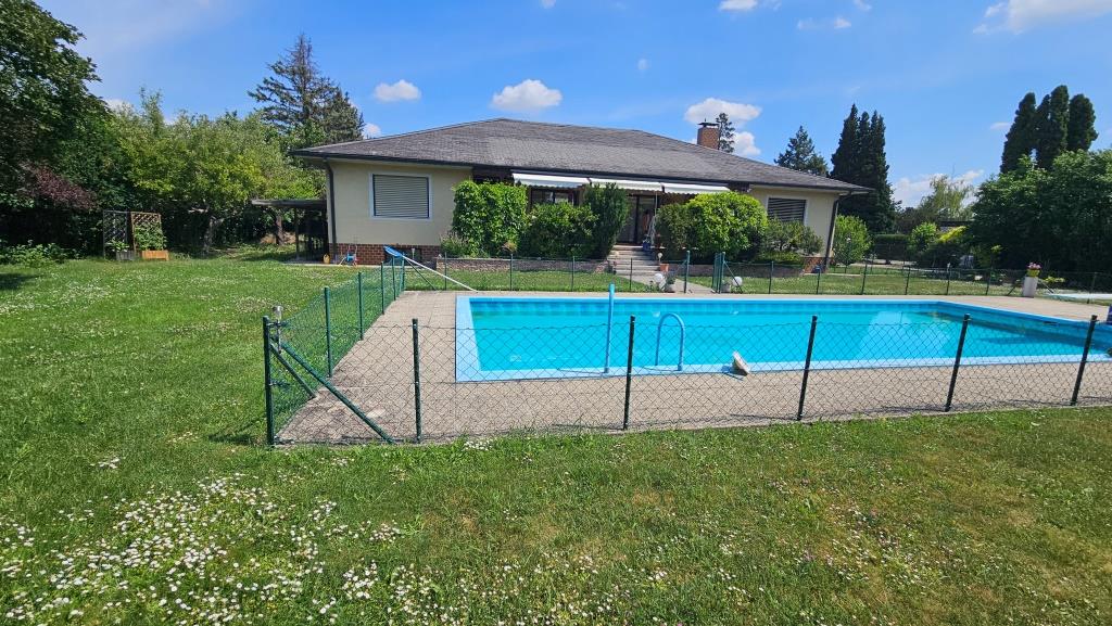 Einfamilienhaus mit Pool und Garten an einem sonnigen Tag