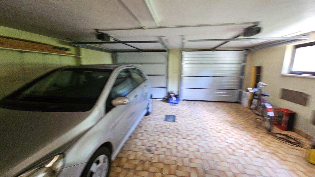 Garagen mit zwei Sektionaltoren, silbernem Auto, Fahrrad und Kiste