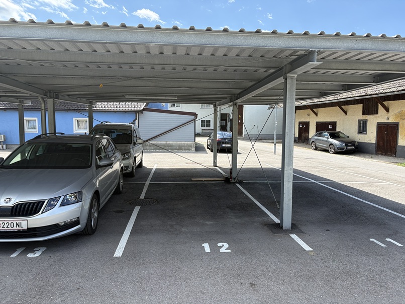 Parkplatz mit Autos unter einem Vordach in Österreich
