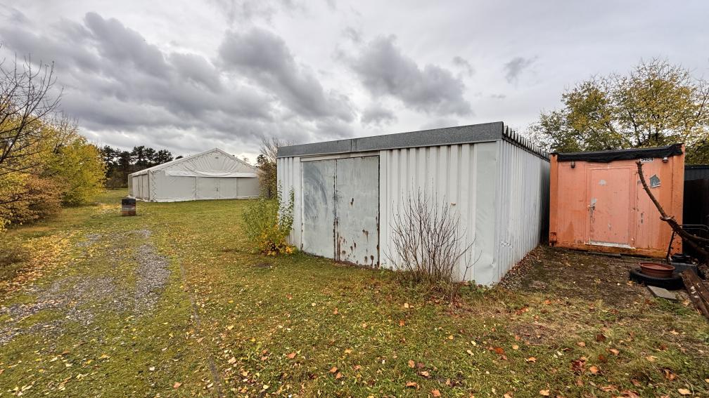 Zelt und Container im Freien unter bewölktem Himmel
