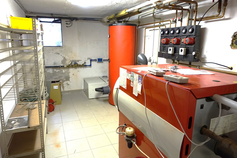 Heizungsanlage mit großem Speicher, Pumpengruppe und Kessel im Keller