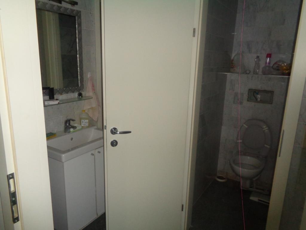 Badezimmer mit Waschbecken, Spiegel und Toilette in einem modernen Haus