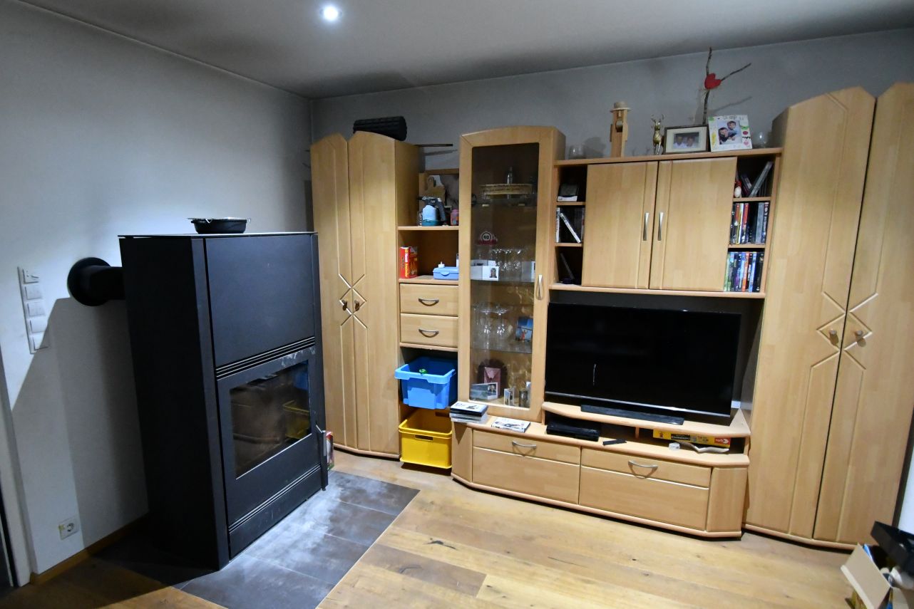 Holzmöbel mit Fernseher, Kaminofen und Gläservitrine