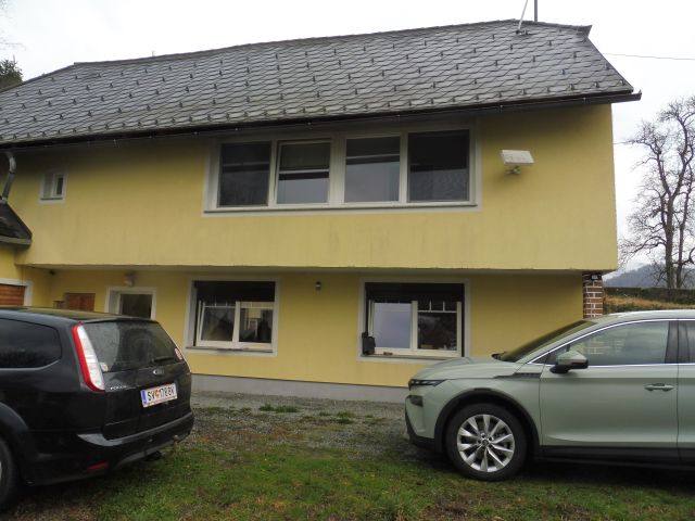 Gelbes Haus mit Autos davor, Steindach, Fenster mit Rollläden, Österreich