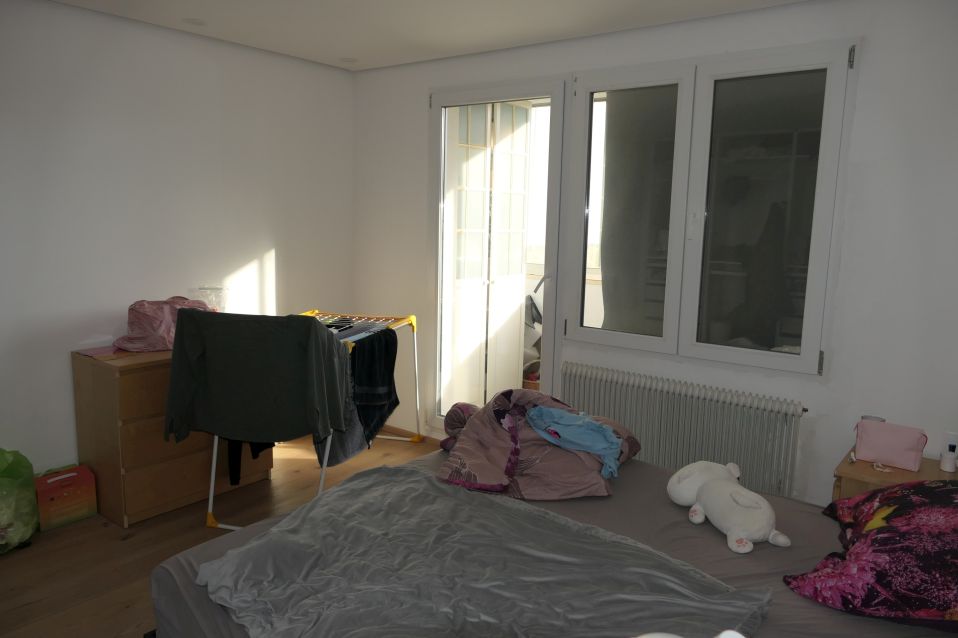 Schlafzimmer mit Wäscheständer und Bett