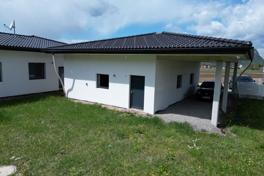 Neubau mit Carport und zwei Autos in ländlicher Umgebung