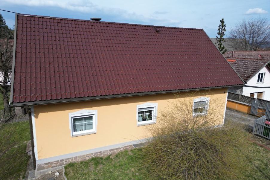 Haus mit gelber Fassade und rotem Ziegeldach in Österreich