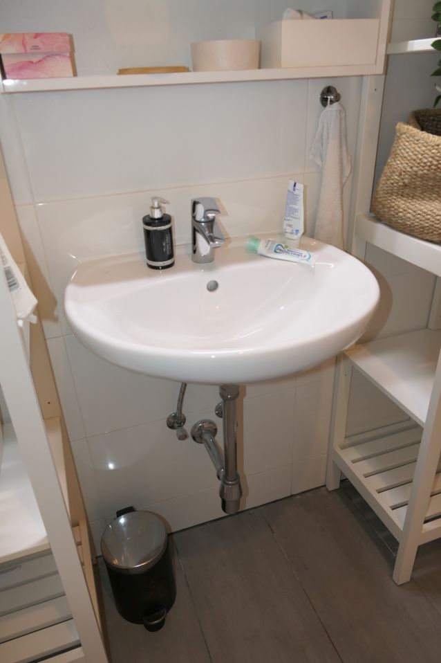 Waschbecken mit Seifenspender, Armatur und Zahnpastatube in einem Badezimmer