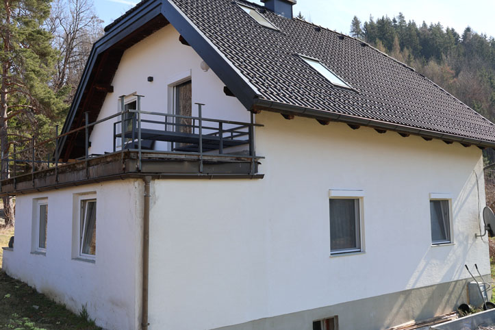 Haus mit Balkon und Dachfenstern in ländlicher Umgebung