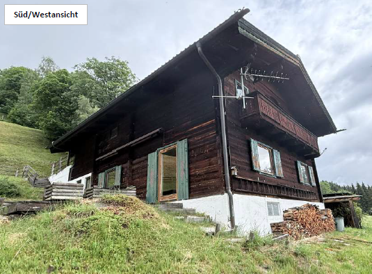 Holzhaus Süd/Westansicht mit Balkon und Holzstapel in den österreichischen Alpen