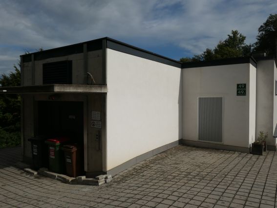 Aufzug mit Mülltonnen und Hausnummer 49 in einem modernen Gebäude