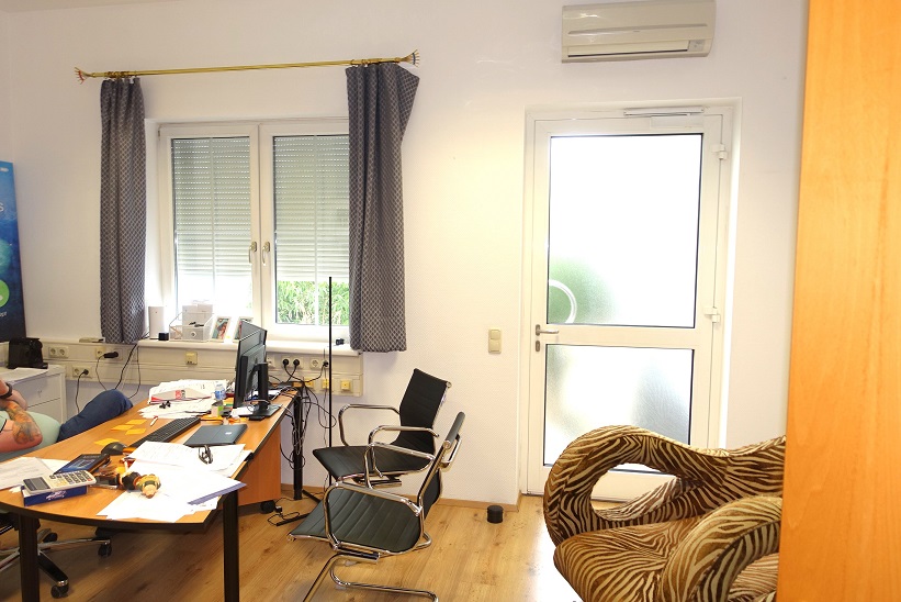 Büro mit Schreibtisch, Computern, Stühlen und Tür in Österreich