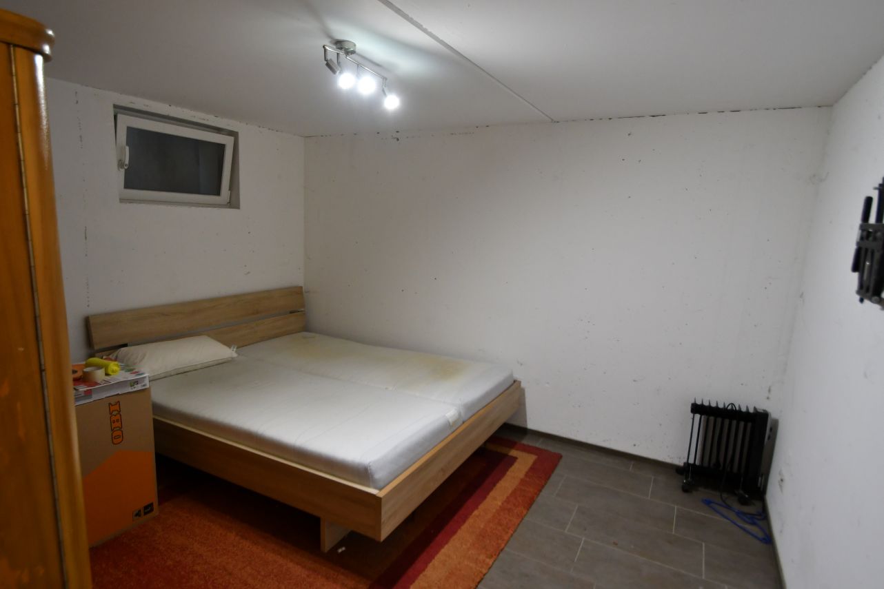 Schlafzimmer mit Bett, Nachtkästchen und Heizkörper