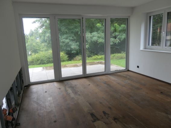 Holzboden mit großen Fenstern und Blick ins Grüne