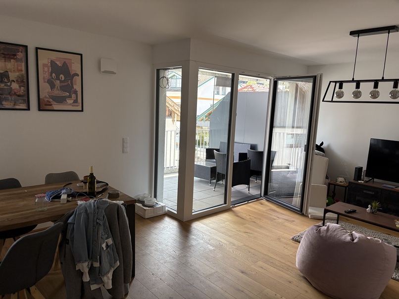 Wohnzimmer mit Essbereich, Balkonmöbeln und Bildern von Katzen